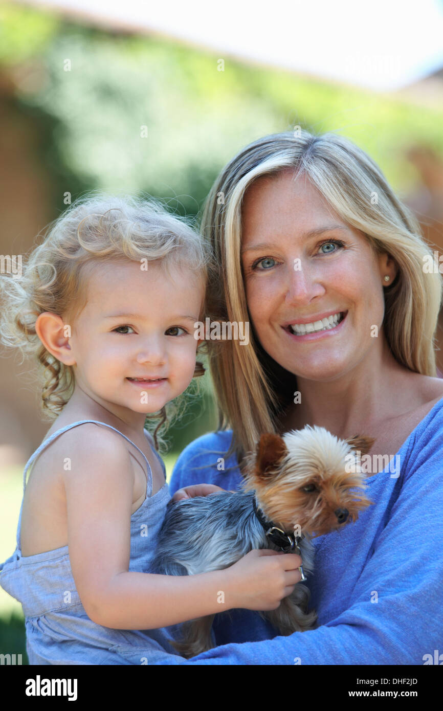 Ritratto di Madre azienda giovane figlia e cane Foto Stock