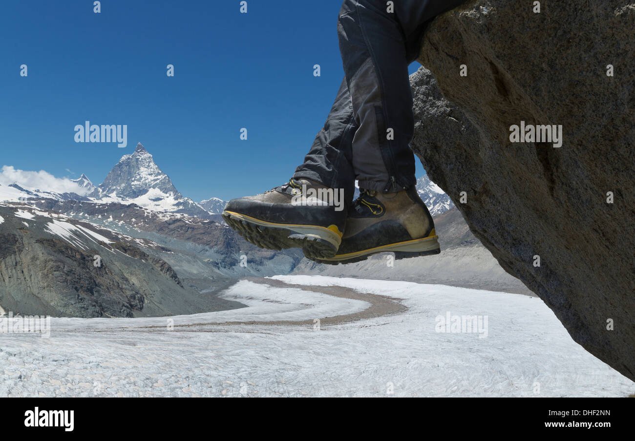 Uomo seduto sulla roccia dal Cervino, Zermatt, Canton Vallese, Svizzera Foto Stock