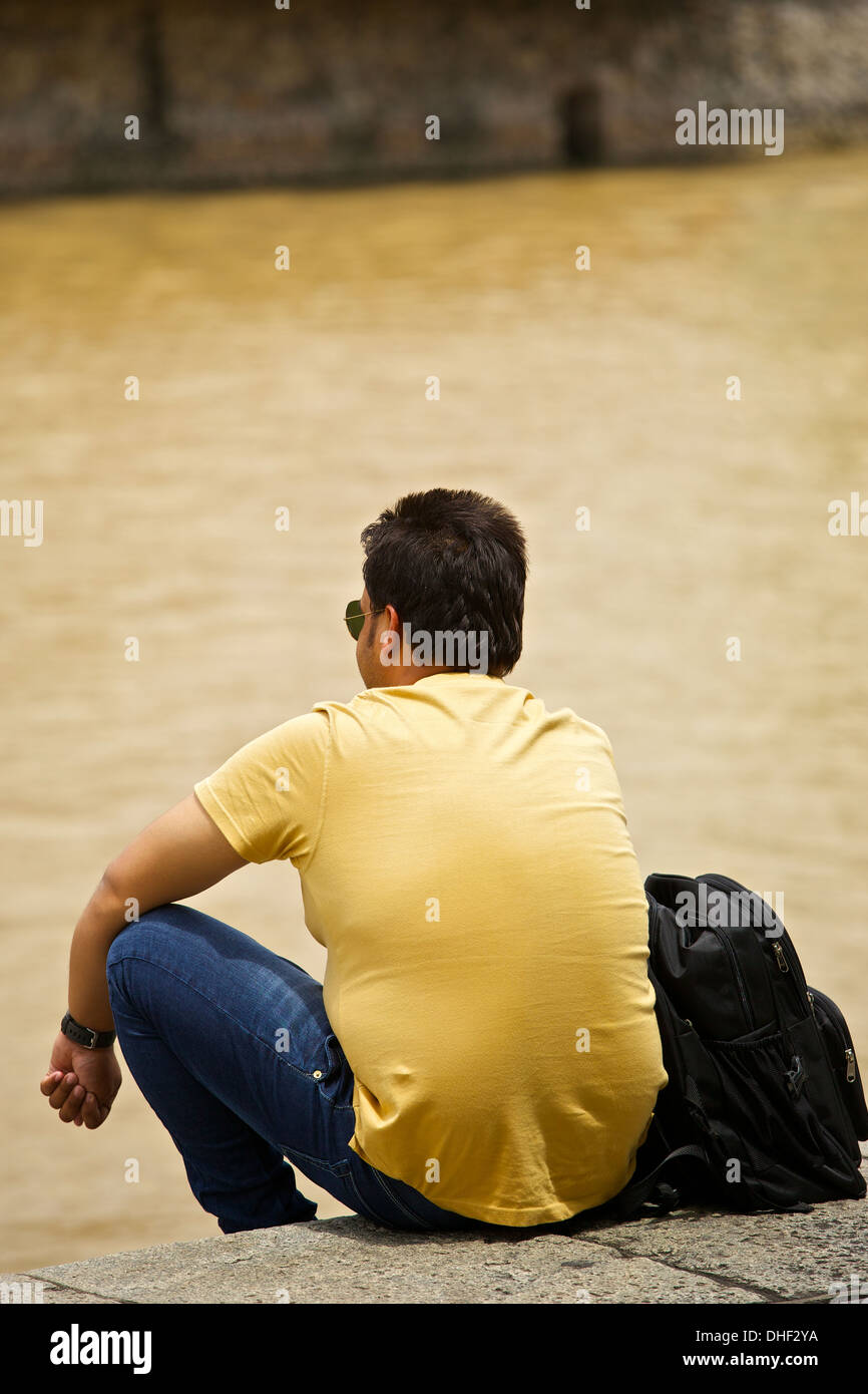 Uomo asiatico appoggiata dal Fiume Singapore. Foto Stock