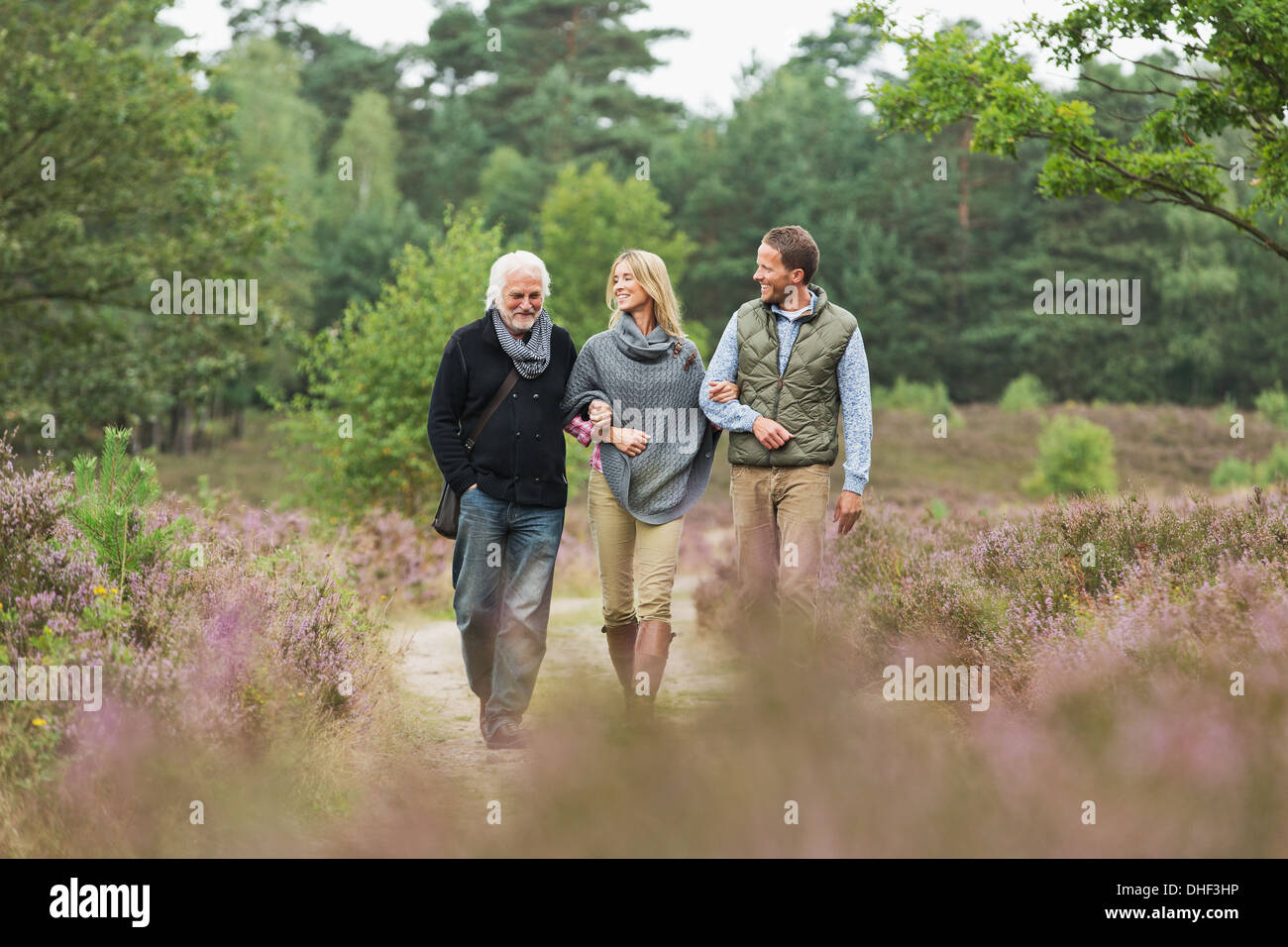 L'uomo anziano, metà adulto uomo e donna camminare attraverso la foresta Foto Stock