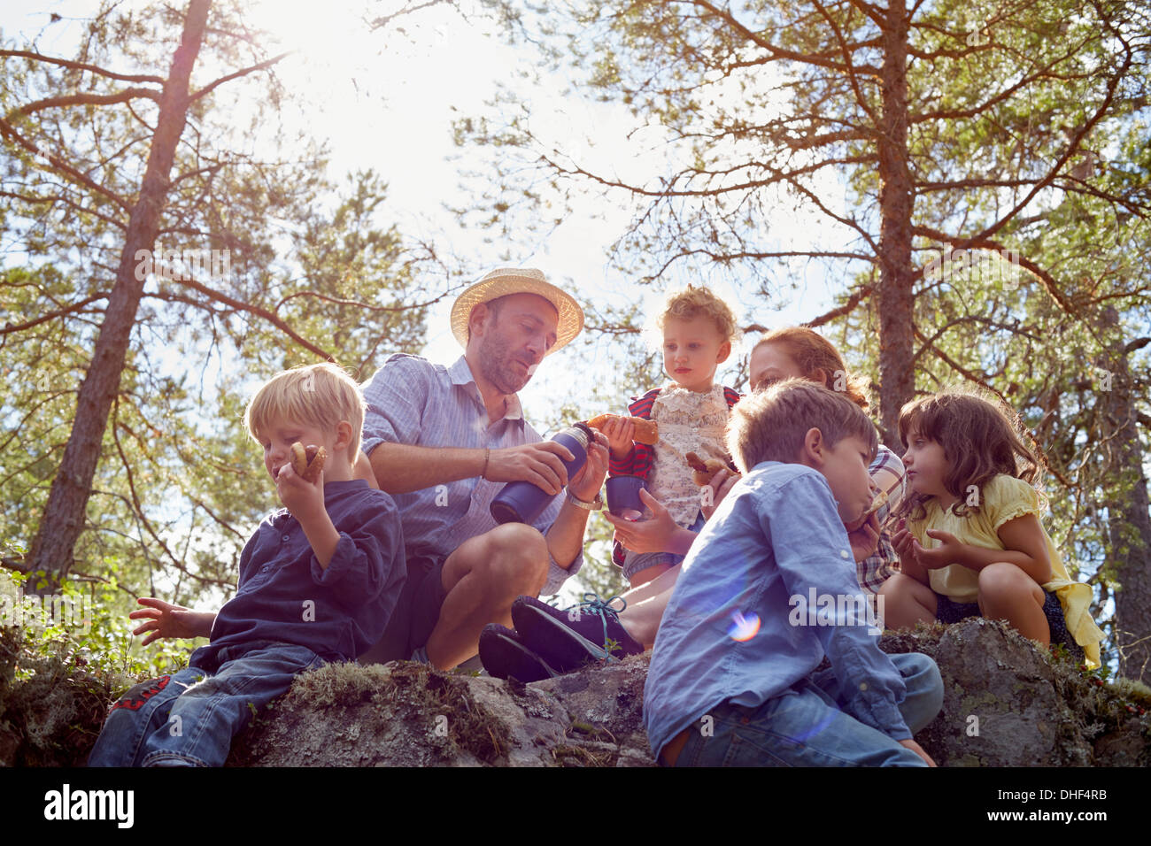 Famiglia avente picnic seduti sulle rocce Foto Stock