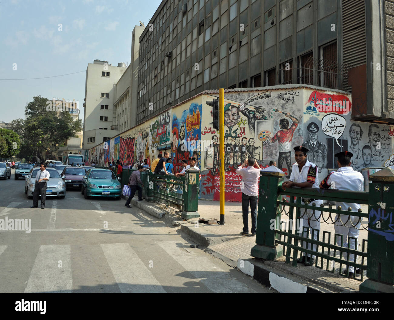 Poliziotto egiziano in uniforme vicino all'arte dei graffiti politici su Mohamed Mahmoud Street, Piazza Tahrir, il Cairo, nel 2012. Foto Stock