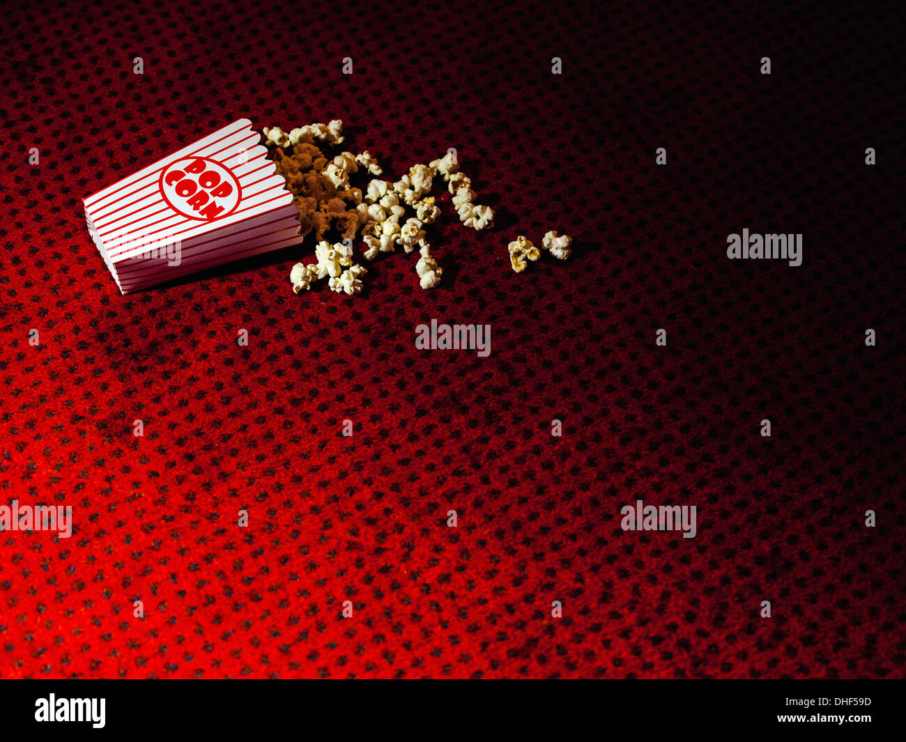 Eventuali fuoriuscite di cartone di popcorn sul tappeto del cinema Foto Stock