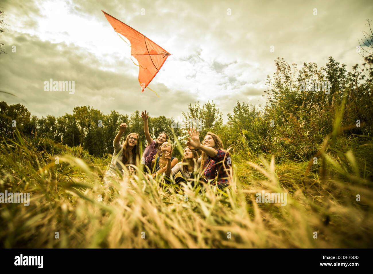 Cinque giovani donne di divertirsi con il kite in macchia Foto Stock