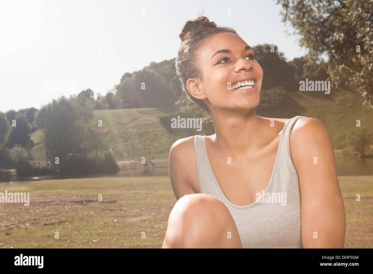 Felice giovane donna alla luce del sole in un parco Foto Stock