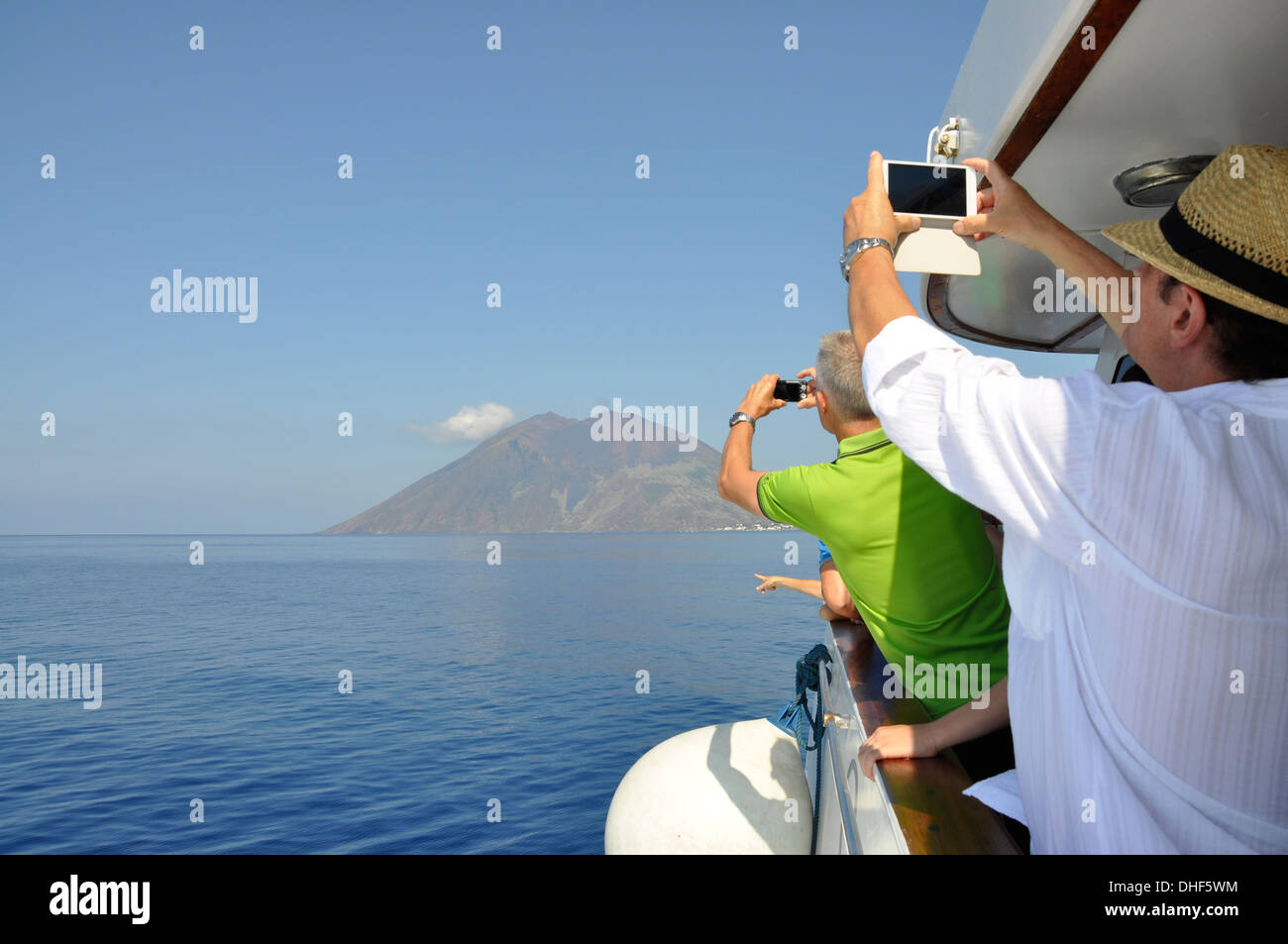 I turisti per scattare delle foto di Stromboli e Vulcano attivo vicino alla Calabria, Italia Foto Stock