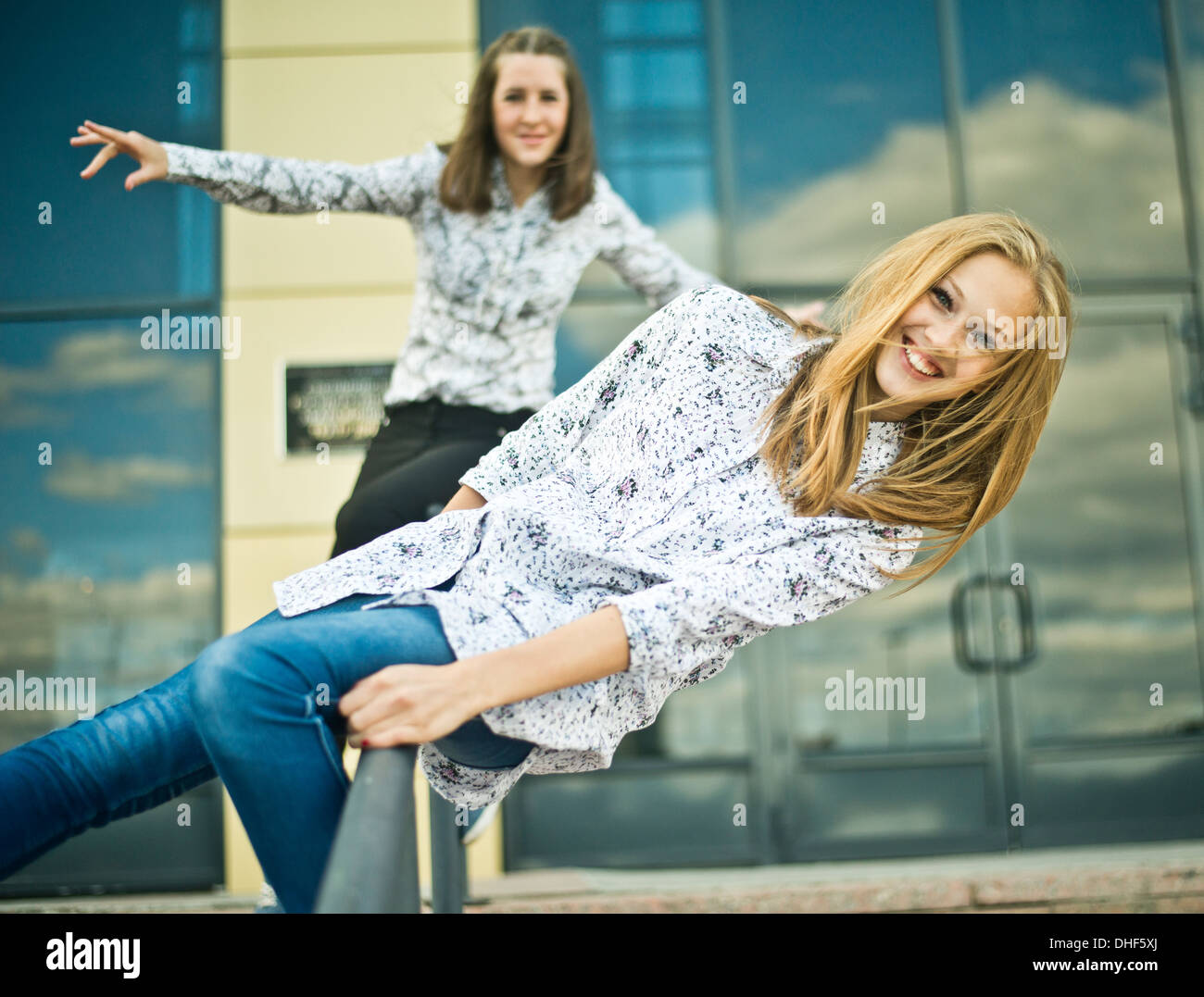 Due giovani donne bilanciata sui parapetti Foto Stock