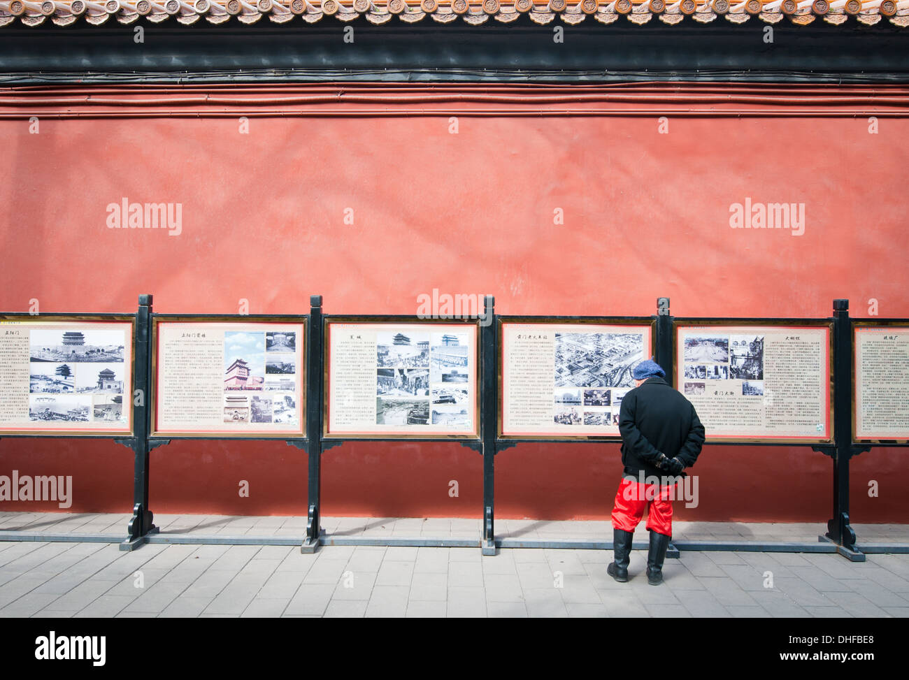 Uomo cinese guardando mostra di archiviazione di fotografie nel Parco Jingshan, Pechino, Cina Foto Stock