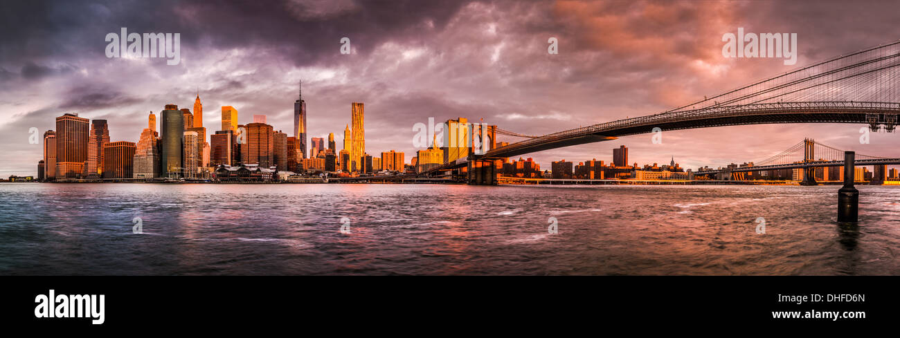 Drammatica alba sopra la parte inferiore di Manhattan e Brooklyn Bridge come vista dal Ponte di Brooklyn Park Foto Stock