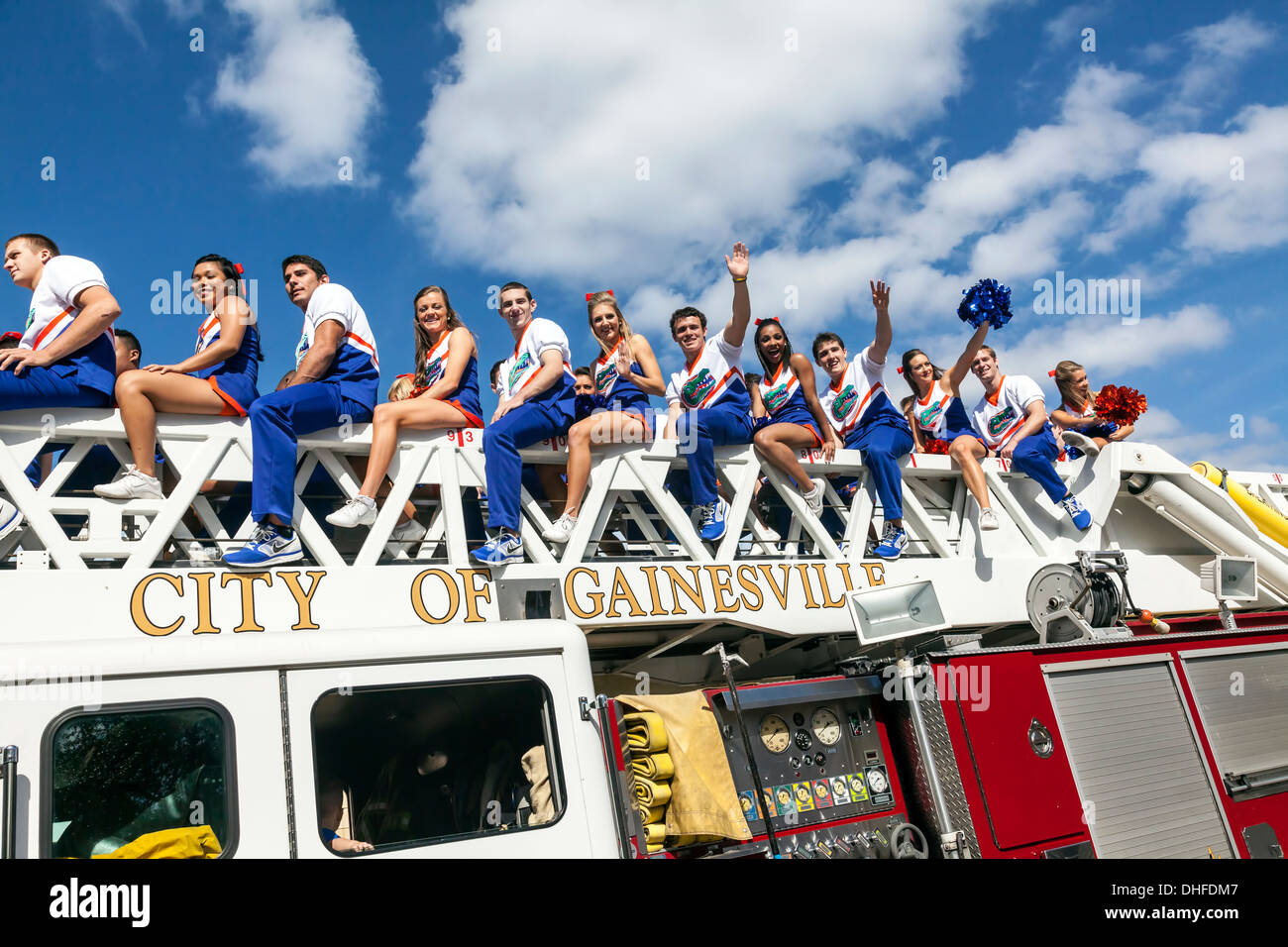 Florida Coed Cheer cheer leader squadra leader a cavallo su un camion dei pompieri nell'università di Florida Homecoming Parade 2013. Stati Uniti d'America Foto Stock