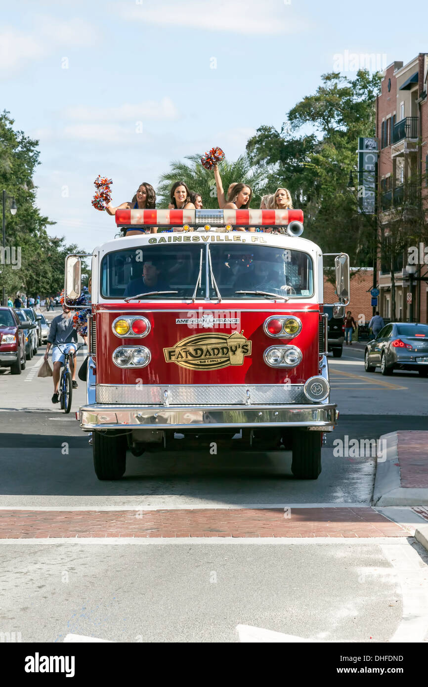 Florida cheer leader squadra a cavallo su un camion dei pompieri nell'università di Florida Homecoming Parade 2013. Stati Uniti d'America Foto Stock