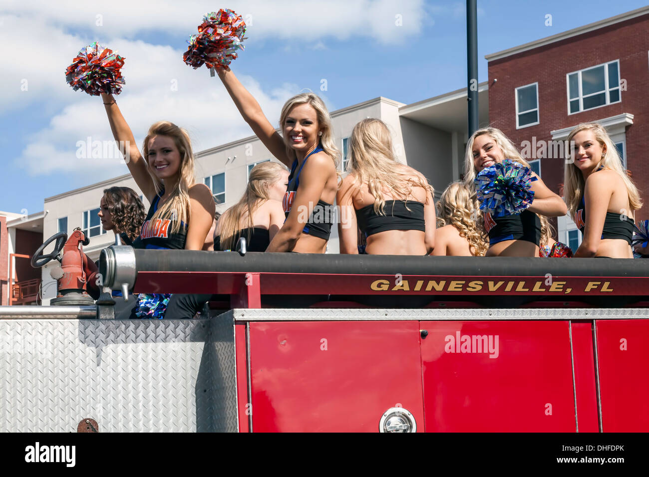 Florida cheer leader squadra a cavallo su camion dei pompieri in università di Florida Homecoming Parade 2013 a Gainesville, Florida. Stati Uniti d'America Foto Stock