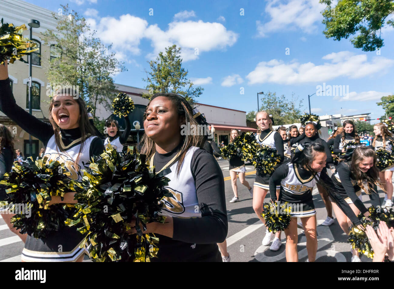 Buchholz High School cheer leader in giallo e nero costumi con oro pom pom, UF 2013 Homecoming Parade. Stati Uniti d'America Foto Stock