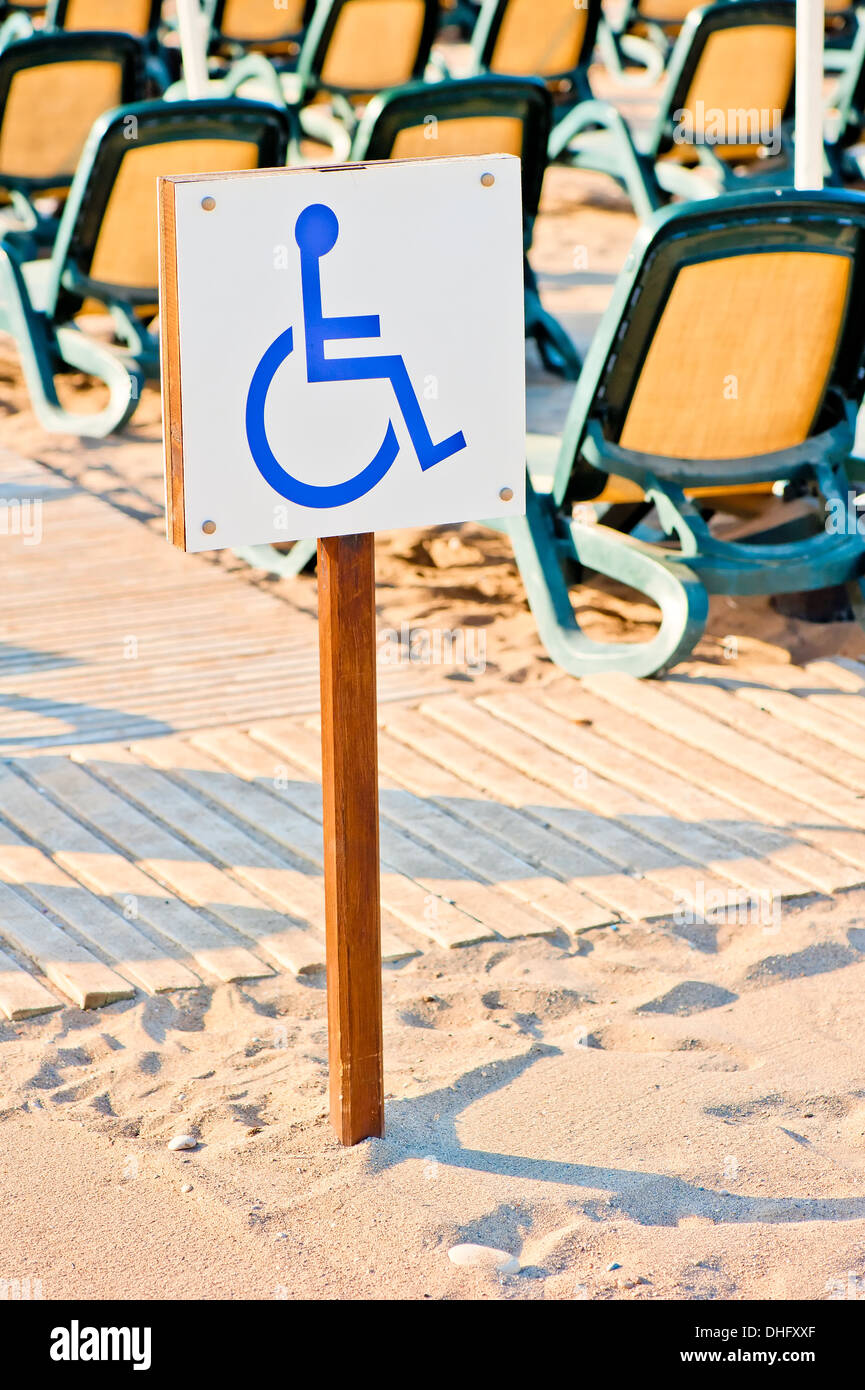 Sedia a rotelle segno impostato sulla spiaggia in riva al mare Foto Stock