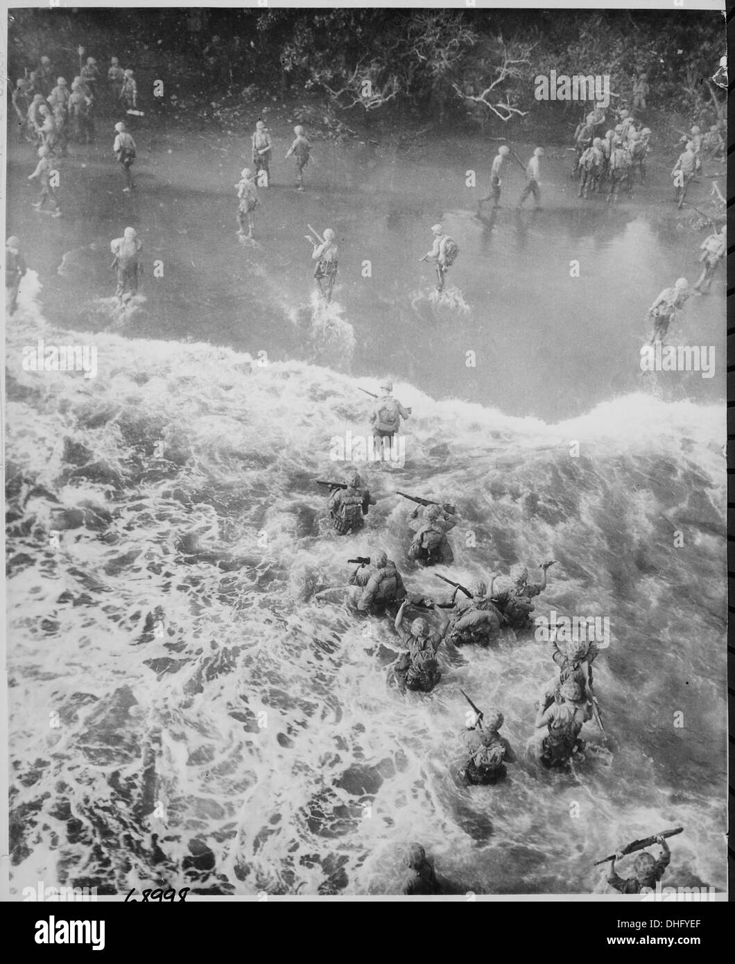 Questa immagine mostra i Marines degli Stati Uniti che attraversano tre metri di acqua accidentata mentre sbarcano dal loro LST (Landing Ship Tank) per assaltare la spiaggia di Cape Gloucester durante la seconda guerra mondiale in nuova Britannia. Foto Stock