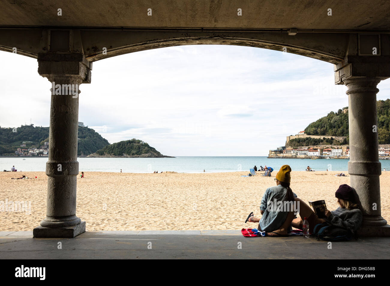 Due giovani turisti appendere fuori all'ombra a Playa La Concha a San Sebastian, Spagna. Foto Stock