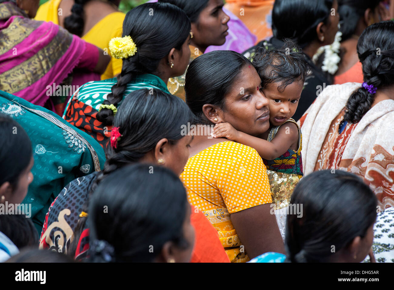 Indian Baby girl abbracci la madre in una folla. Andhra Pradesh, India Foto Stock