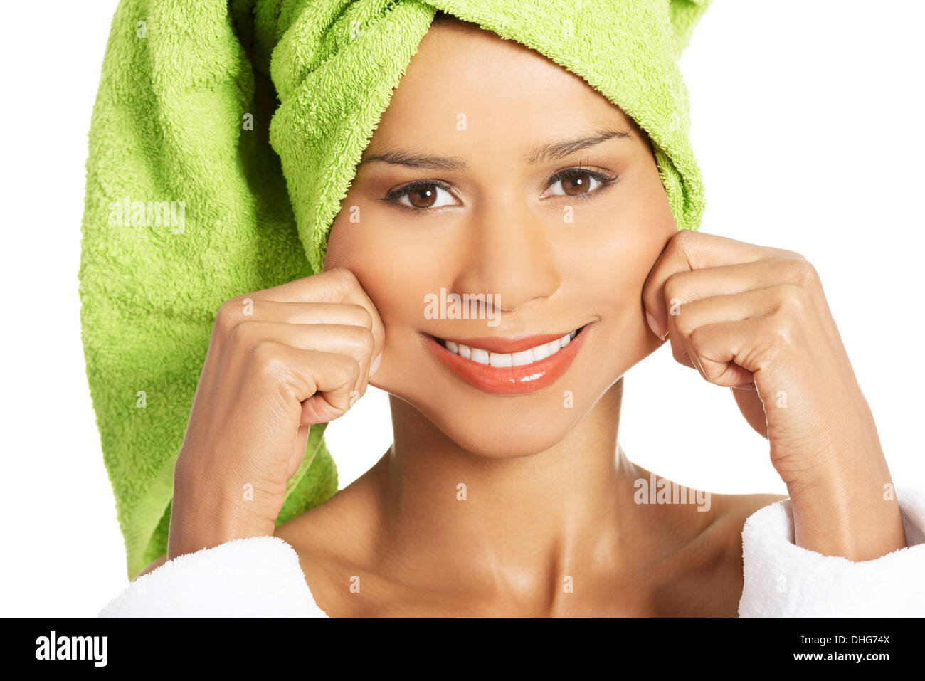 Donna attraente avvolto in un asciugamano tenendo la bocca in un sorriso. Isolato su bianco. Foto Stock
