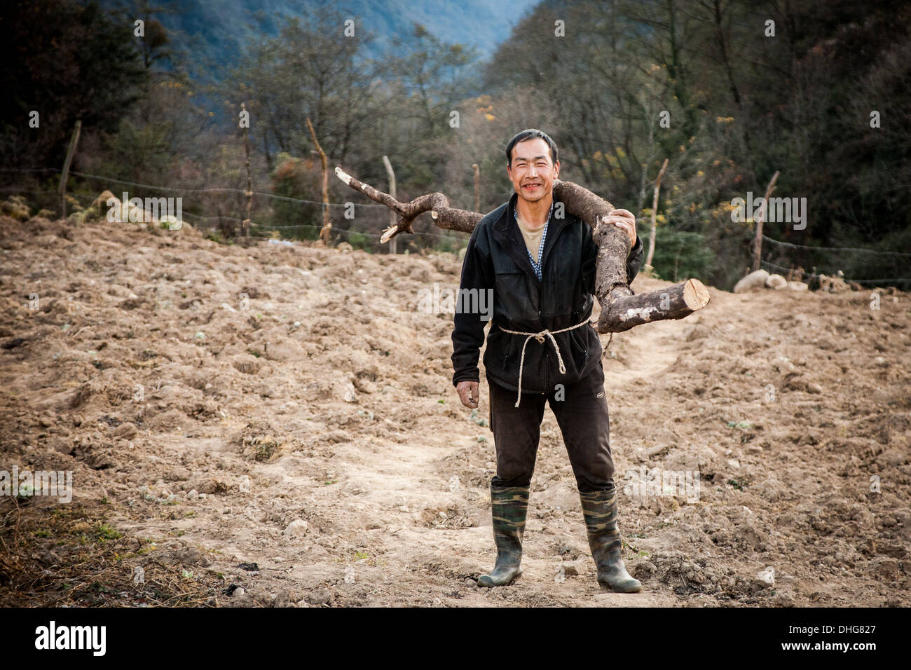 Un agricoltore bhutanesi portando alcuni di legna da ardere Foto Stock