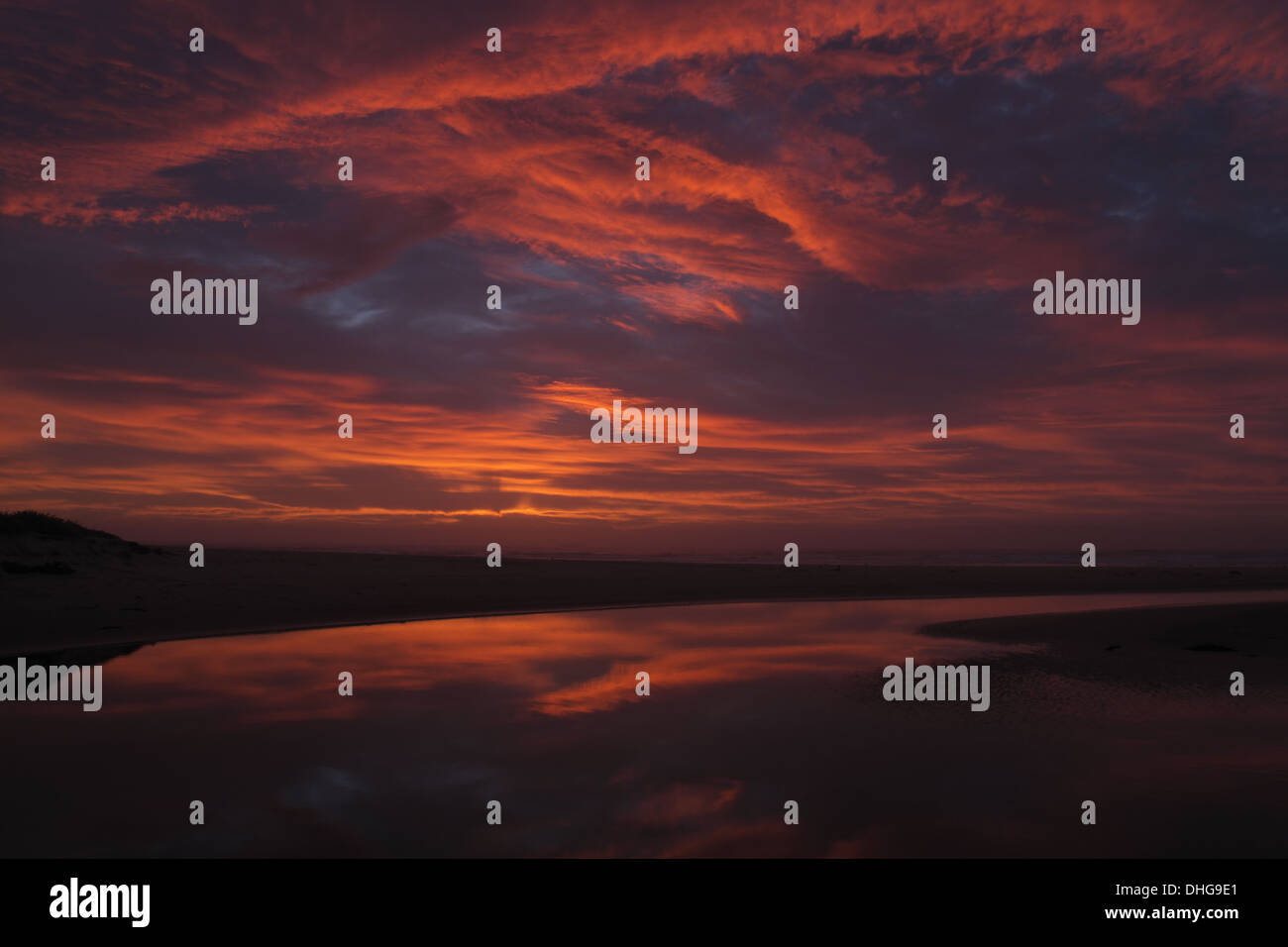 Cloud frontale al mattino twilight, riflesso nel fiume stagno, Corrimal Beach Australia Foto Stock