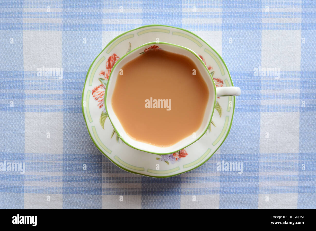Una tazza di tè di latte su una tovaglia a scacchi. Foto Stock