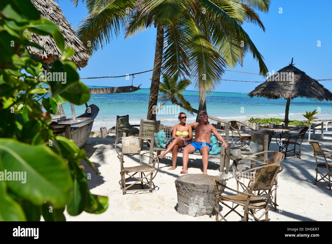 Coppia giovane seduto a lato della spiaggia hotel bar, spiaggia Bwejuu, Oceano Indiano, Zanzibar, Tanzania Africa orientale Foto Stock