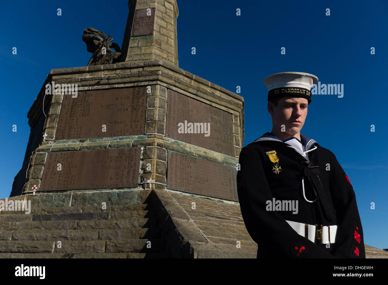 Aberystwyth Wales UK, domenica 10 novembre 2013. Un solitario mare cadet sorge sotto il monumento ai caduti in guerra a Aberystwyth sul ricordo domenica 2013. Centinaia di persone hanno assemblato sul promontorio al castello in Aberystwyth a testimoniare la cerimonia annuale. I rappresentanti delle forze armate e di molti gruppi locali di cui papavero rosso ghirlande alla base della città iconici memoriale di guerra che si affaccia al mare. Foto © keith morris Credito: keith morris/Alamy Live News Foto Stock