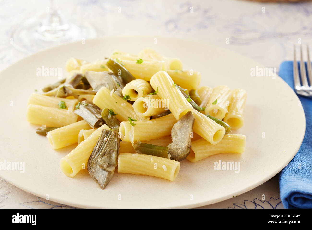 Elicoidale pasta con carciofi e fagioli verdi pasto in una tavola riccamente ornati Foto Stock