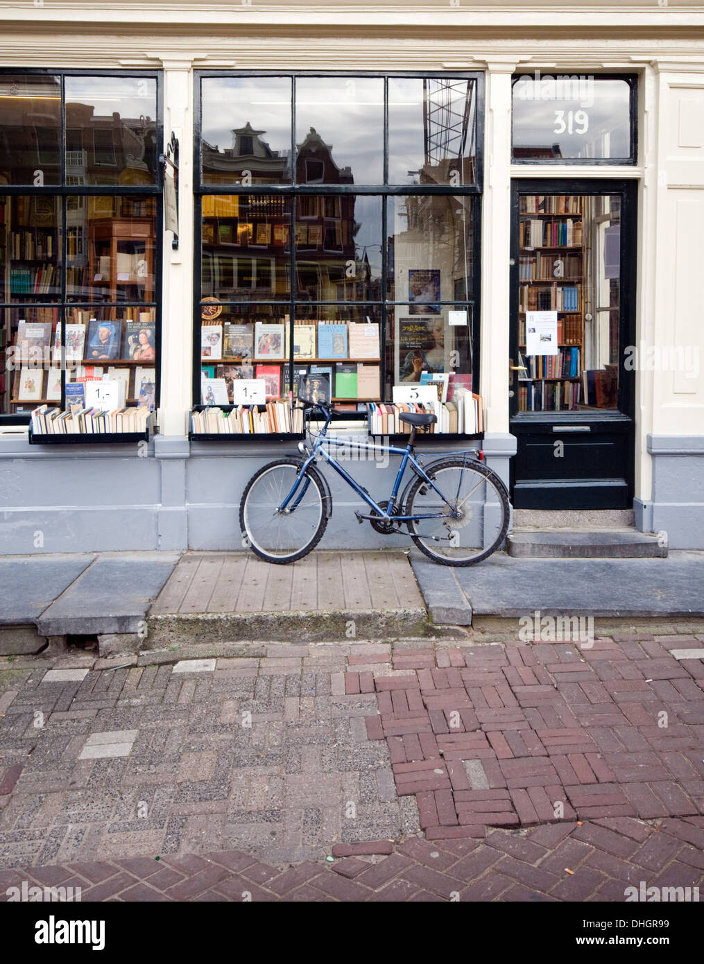 Bike appoggiata contro la finestra di un book shop in Amsterdam, Paesi Bassi Foto Stock