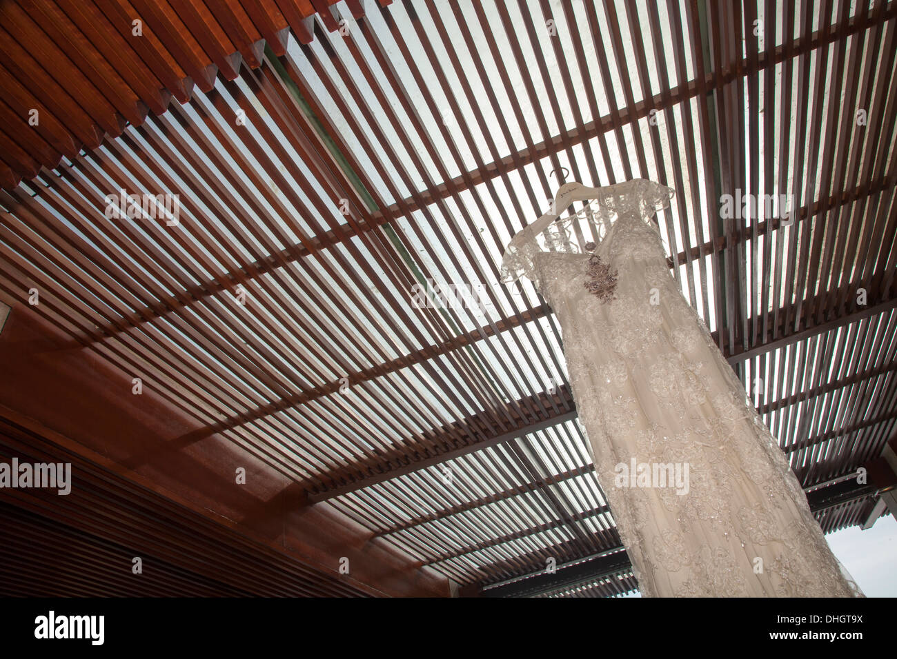 Abito da sposa appeso tetto in legno top sun matrimonio sunny preparazione vestiti decor della decorazione creative sparare scatti foto di luce Foto Stock