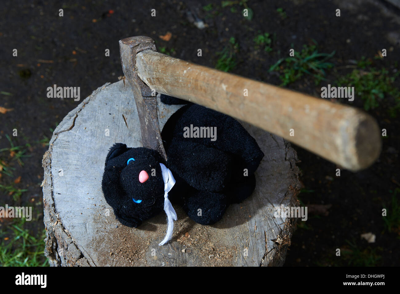 Esecuzione - omicidio del bambino giocattolo di peluche gatto nero con un'ascia Foto Stock