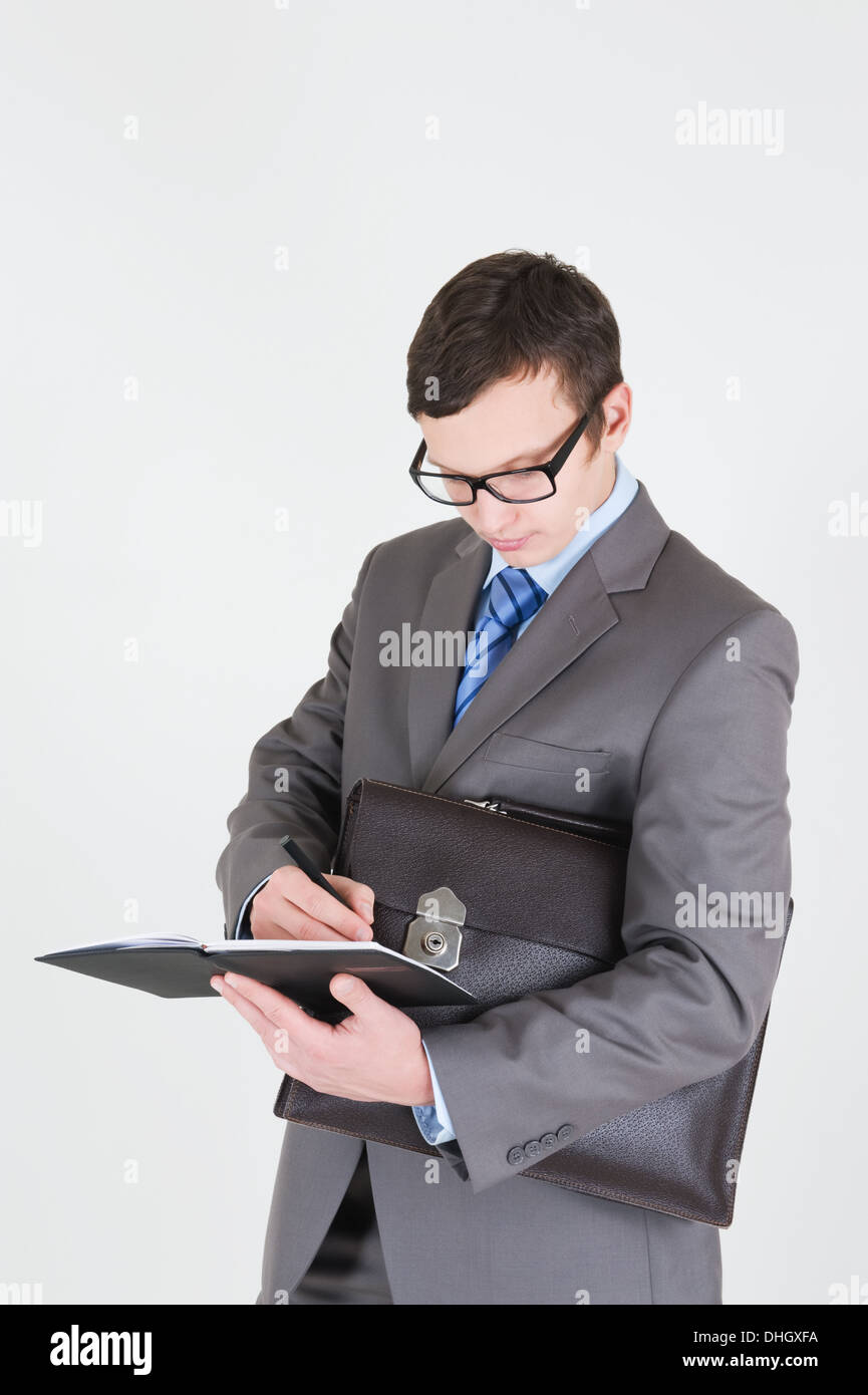 Ritratto di bel giovane imprenditore con notebook e valigetta Foto Stock
