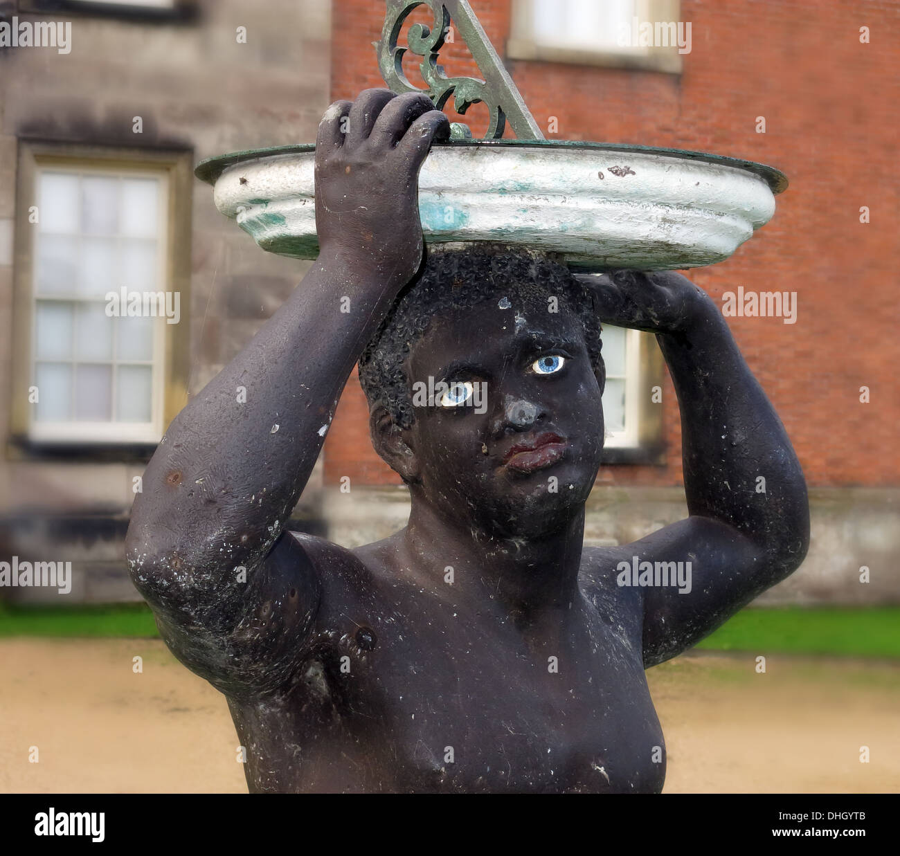 Black African che tiene la meridiana a Dunham Massey Hall , vicino a Altrincham Cheshire Inghilterra , Regno Unito WA14 4SJ. BLM, Statua Nera, Black Lives conta? Foto Stock