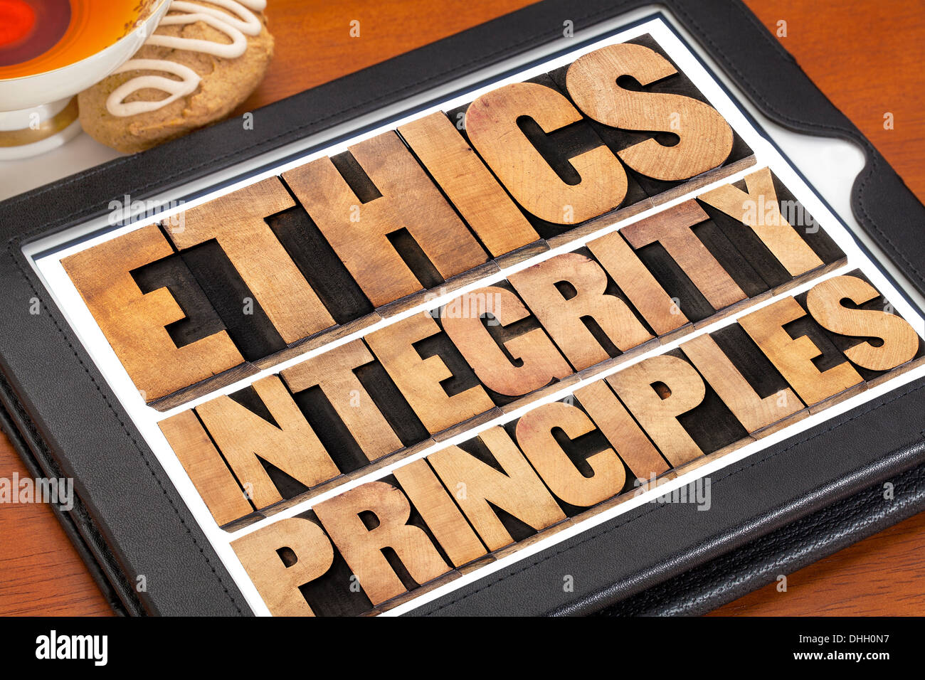 Etica e integrità e di principi astratti di parola - concetto etico su una tavoletta digitale con una tazza di tè Foto Stock