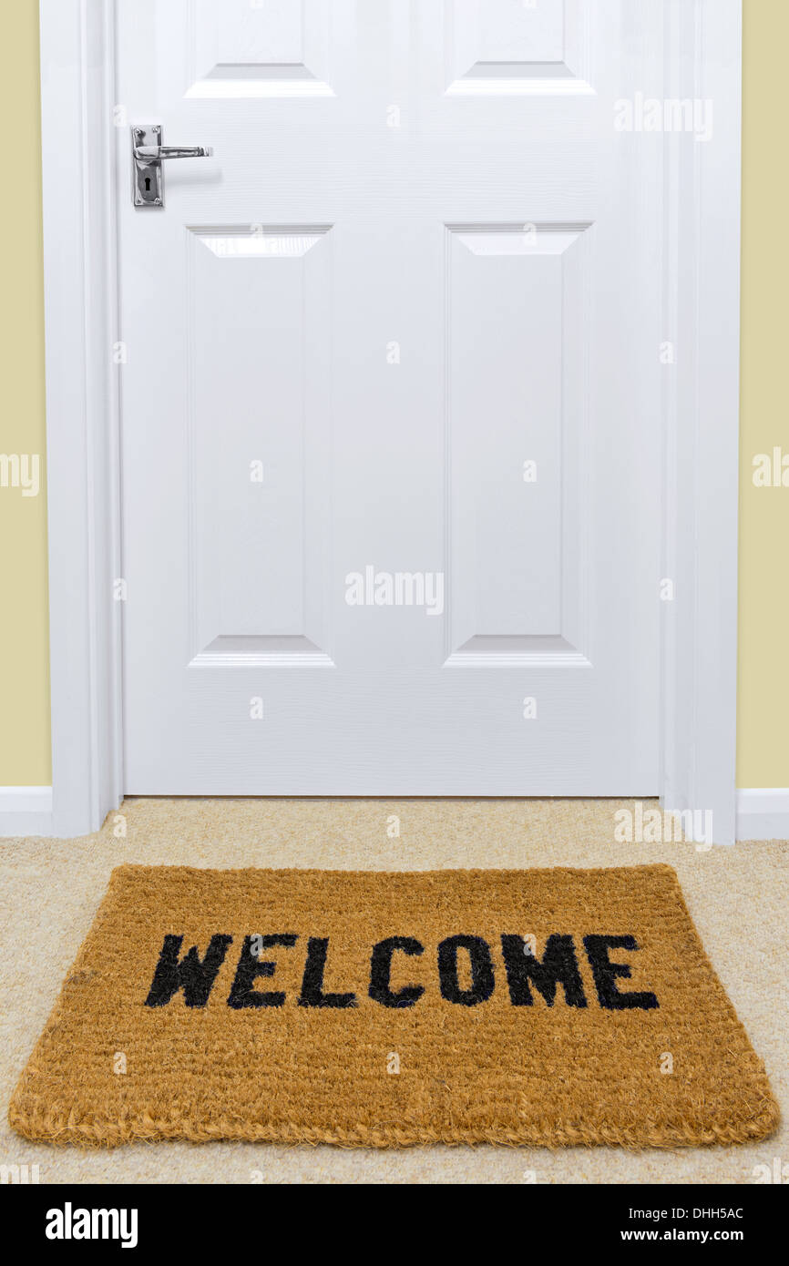 Un benvenuto zerbino davanti a una porta. Foto Stock