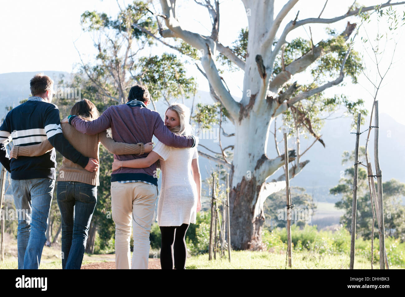 Amici passeggiate attraverso la campagna con le braccia intorno a Foto Stock