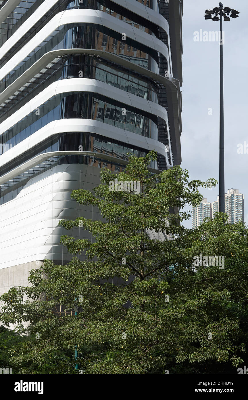 Torre di innovazione, Kowloon, Hong Kong. Architetto: Zaha Hadid Architects, 2013. Dettaglio della parte esterna con grattacieli in background. Foto Stock