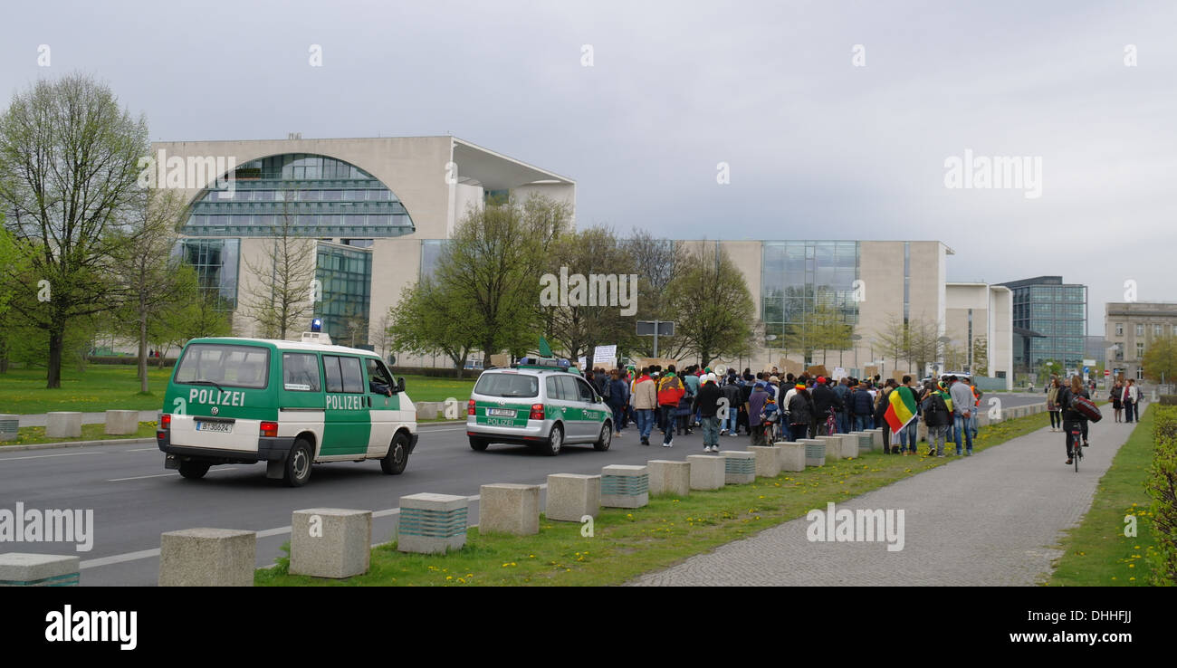 Cielo grigio visualizza auto della polizia a seguito dei diritti umani etiopi che marciano alla nuova cancelleria, Henrich von Gagern Strasse, Berlino Foto Stock