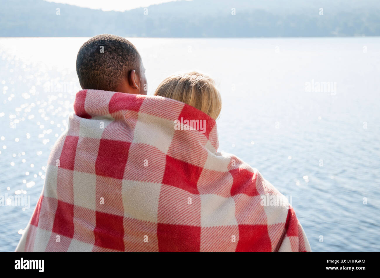 Coppia giovane avvolto in una coperta dal lago, Hadley, New York, Stati Uniti d'America Foto Stock