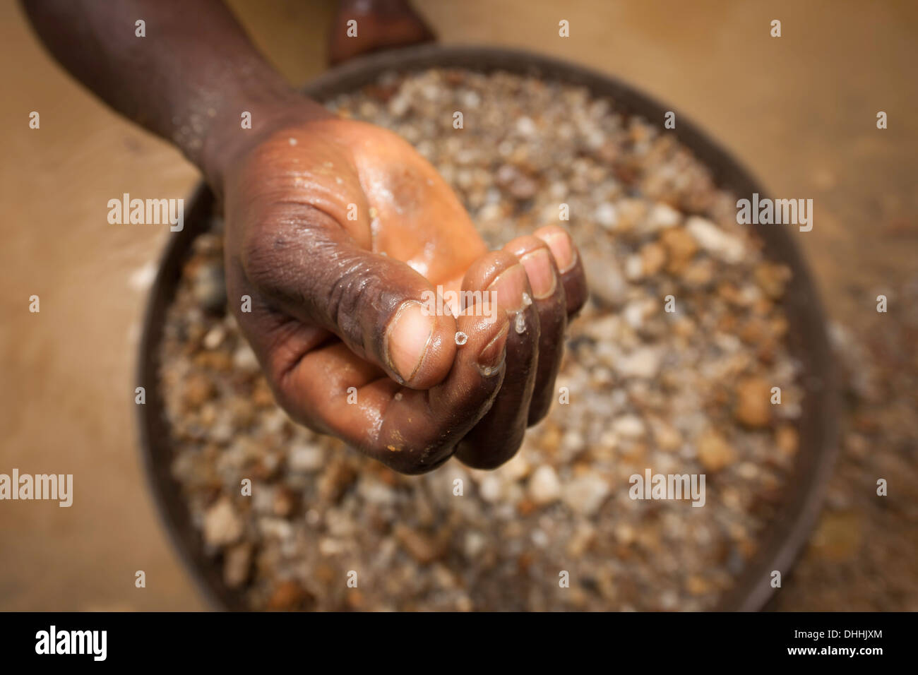 Trovare un piccolo diamante, circa due carat, dalla schermata di lavaggio di un minatore di diamante, Kenema, Provincia Orientale, Sierra Leone Foto Stock