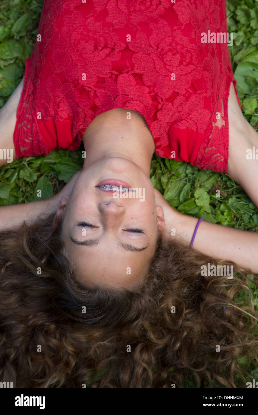 Close up della ragazza adolescente sdraiati sull'erba Foto Stock