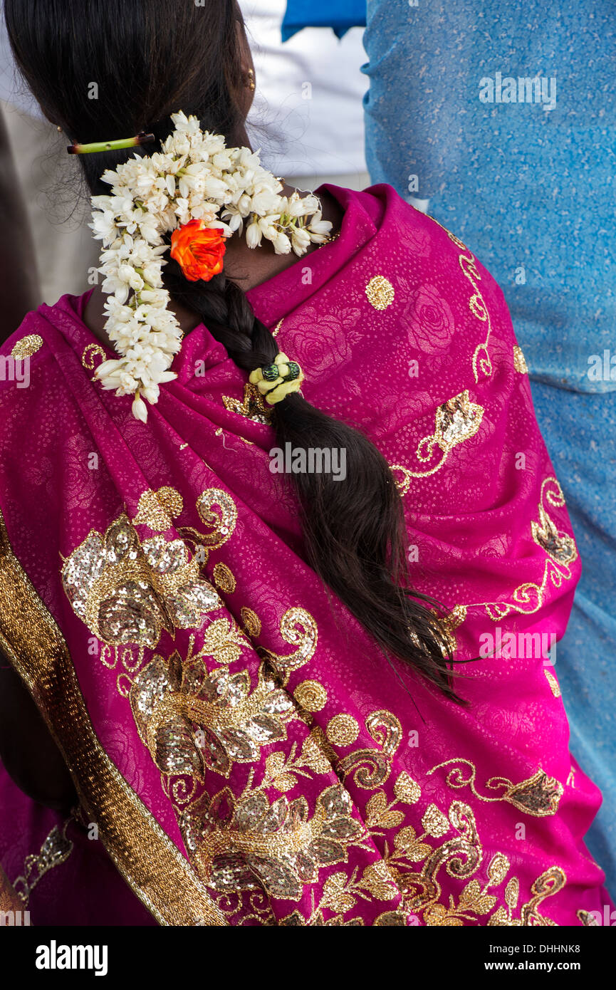 Donna indiana rosa sari e ghirlanda di fiori tra i capelli da dietro. Andhra Pradesh, India Foto Stock
