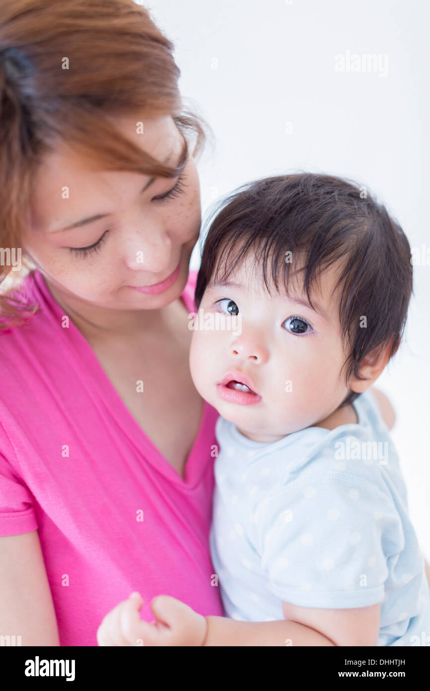 Madre che guarda il bambino nelle braccia Foto Stock