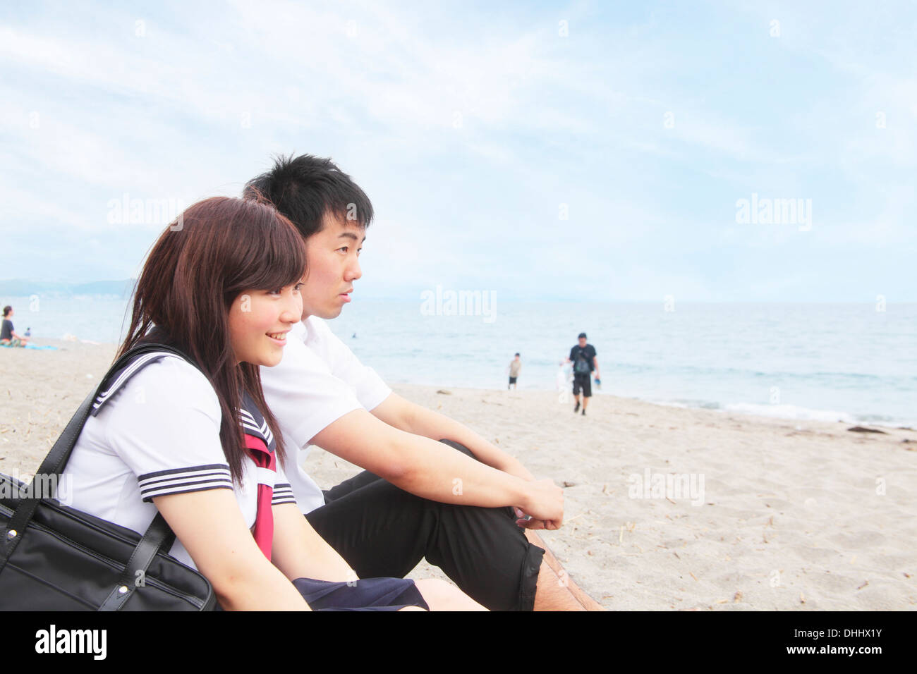 Coppia giovane seduto sulla spiaggia sabbiosa Foto Stock