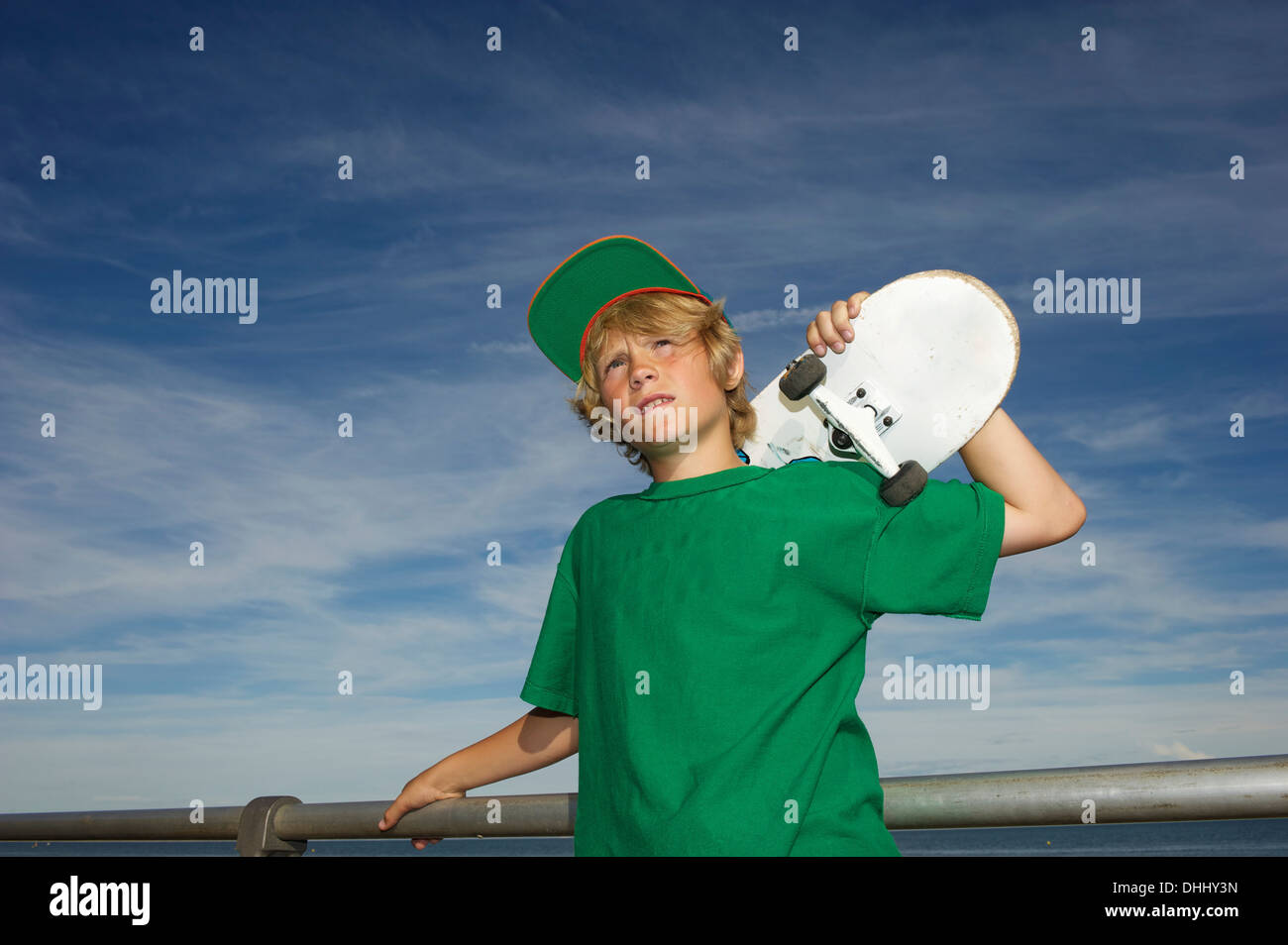 Ritratto di ragazzo holding skateboard sulla spalla Foto Stock