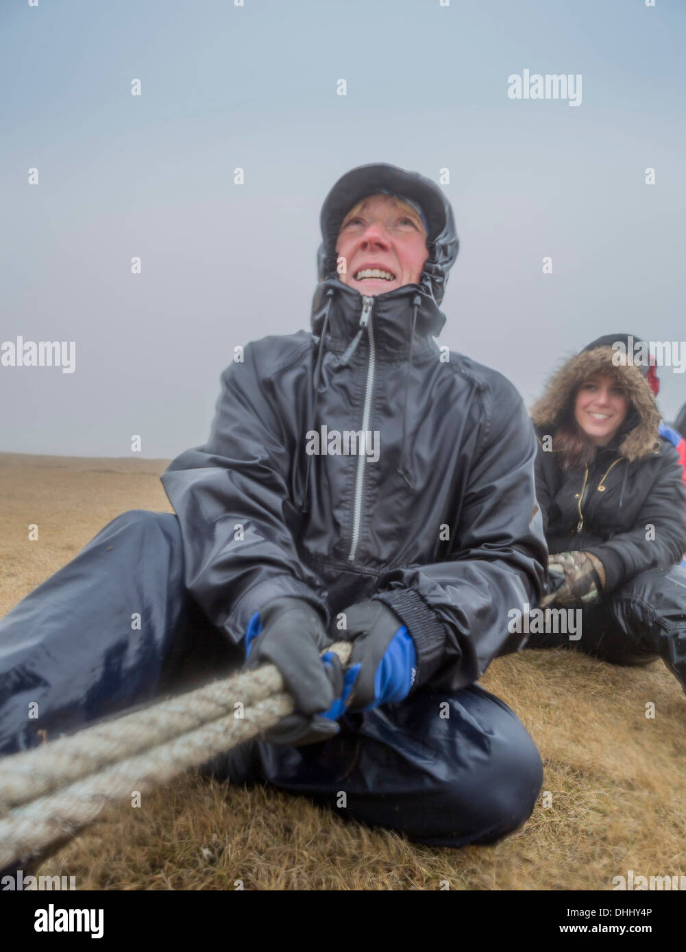 Il lavoro di squadra sforzo da parte della corda per raccogliere le uova sulle scogliere. Comune di raccolta Guillemot uova (Uria aalge), Ingolfshofdi, Islanda Foto Stock