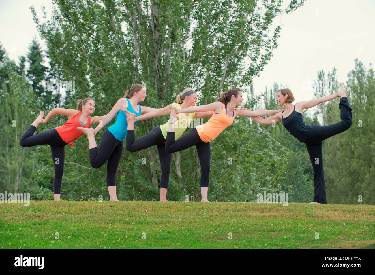 Le ragazze adolescenti e insegnante di yoga in piedi su una gamba Foto Stock