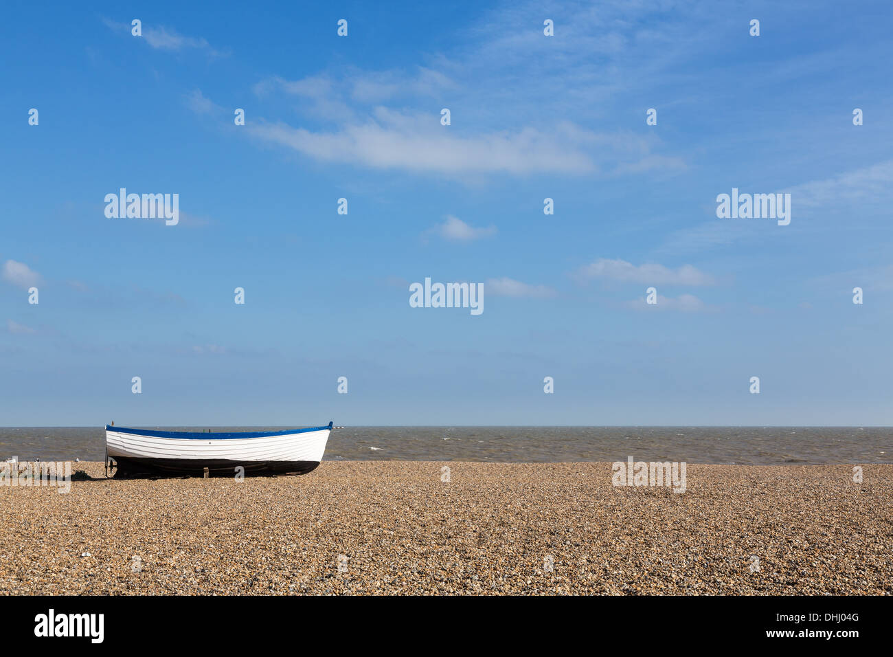 Spiaggia di Aldeburgh nel Suffolk e costa orientale dell'Inghilterra, Regno Unito con la vecchia barca in legno sulla ghiaia Foto Stock