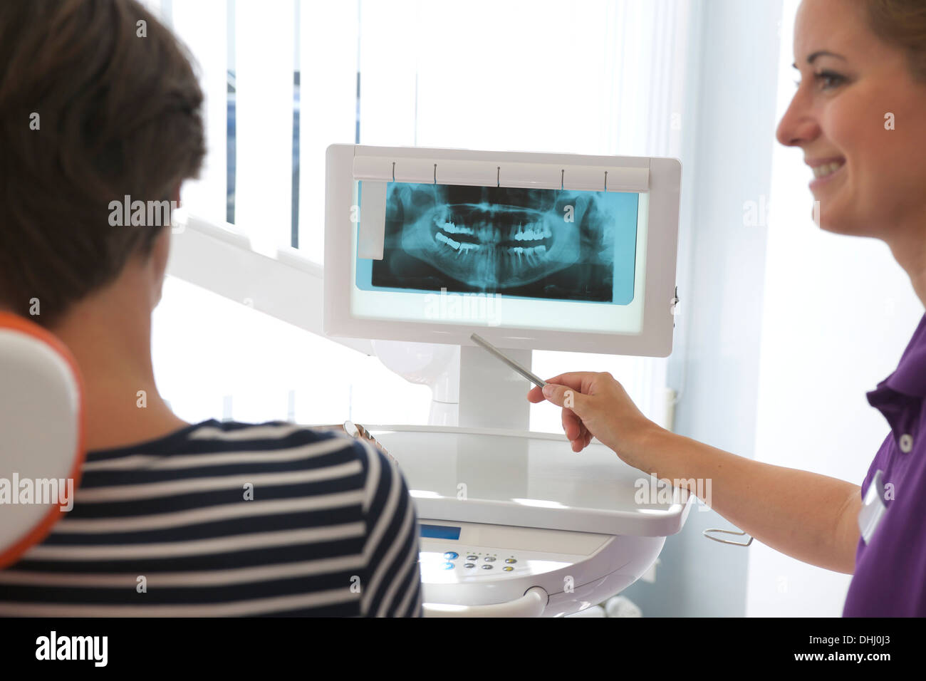 Paziente guardando xray di impianti dentali Foto Stock