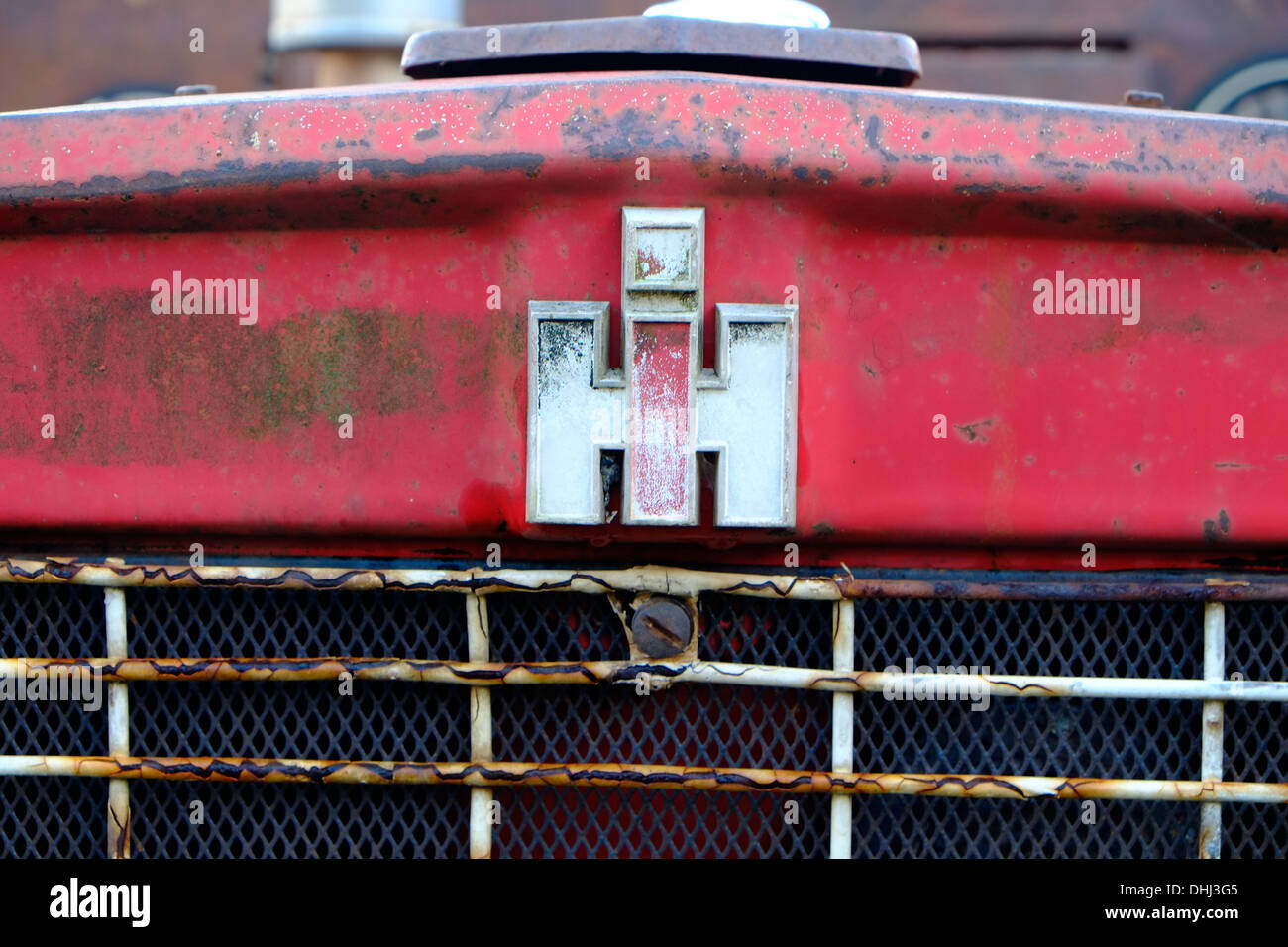 Primo piano di una parte di un trattore International Harvester arrugginito rosso pronto per il ripristino. Devon, Regno Unito Foto Stock